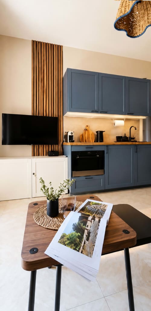 Cucina moderna con mobili blu e dettagli in legno all'appartamento ViOletta, Lido di Ostia, con tavolo da pranzo
