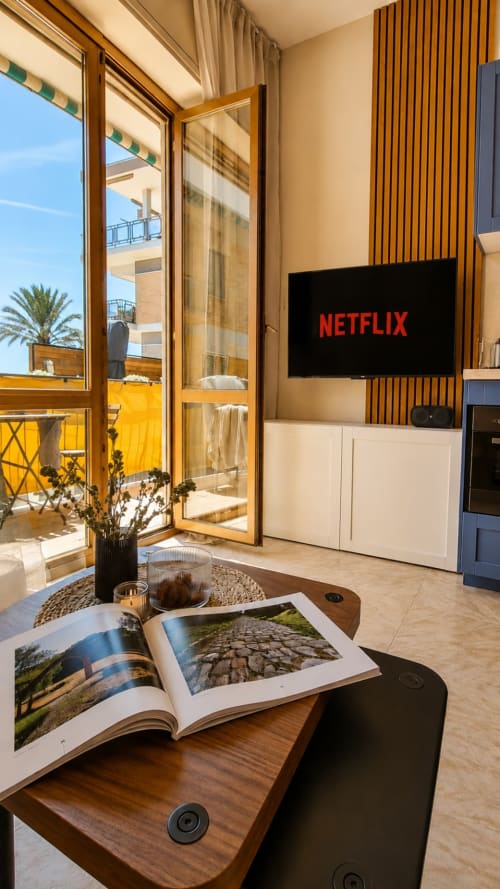 Soggiorno moderno all'appartamento ViOletta, Lido di Ostia, con TV Netflix, arredi in legno e balcone con vista mare