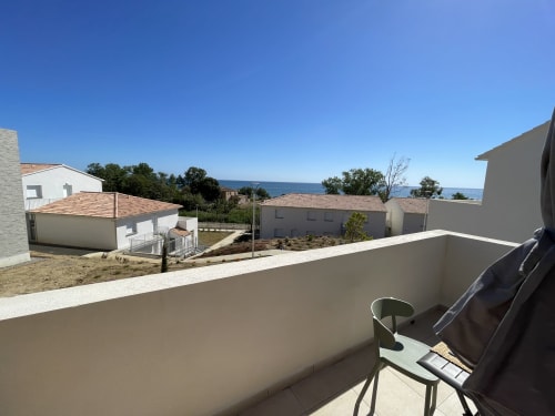 Vista dal balcone della Résidence Marina di Bravone, Linguizzetta, con vista sulla spiaggia e sul mare con edifici residenziali moderni