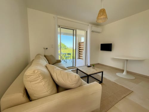 Moderno monolocale con vista mare presso la Residenza Marina di Bravone, divano beige, TV a schermo piatto e accesso privato
