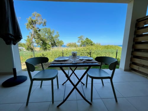 Terrazza monolocale fronte mare a Marina di Bravone con tavolo da pranzo, vista mare e accesso diretto alla spiaggia a Linguizzetta