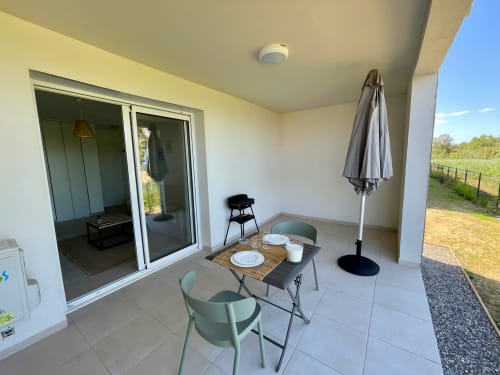 Terrazza di monolocale moderno alla Résidence Marina di Bravone con tavolo da pranzo, vista mare e accesso alla spiaggia a Linguizzetta