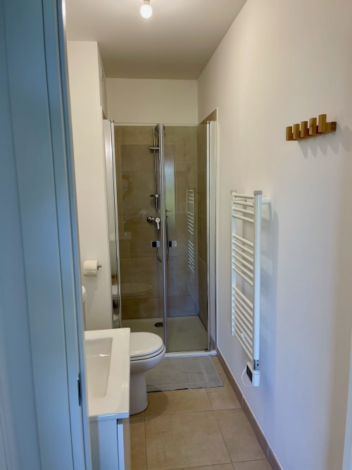 Bagno moderno dello Studio Marina di Bravone, Linguizzetta con doccia con box in vetro, scaldasalviette bianco e WC