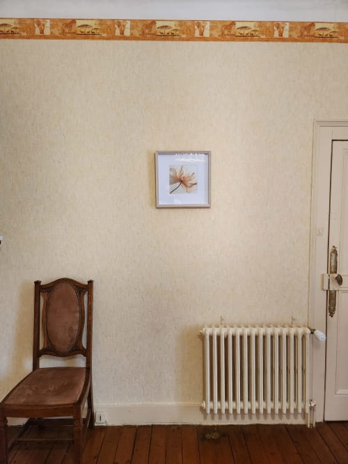 Spacieuse chambre de villa à Charly avec chaise bois classique, radiateur et tableau floral encadré sur papier peint crème