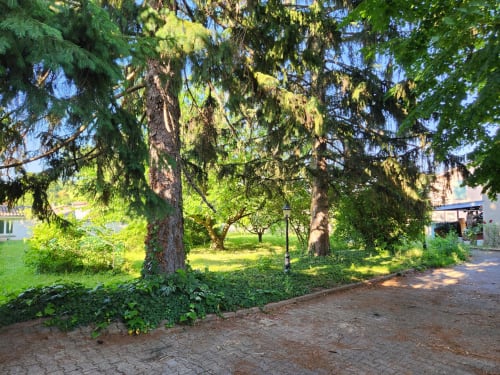Jardin verdoyant avec arbres matures et allées à la villa Jolie Maison à Charly, France