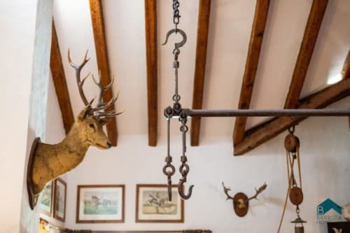 Vigas rústicas y astas de ciervo montadas en el hotel Barrosa Home, mostrando la decoración tradicional española