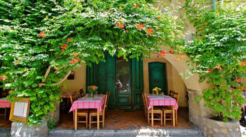 Charming outdoor dining area at Pipa Polaris B&B in Spéracèdes with ivy-covered walls and red checkered tables