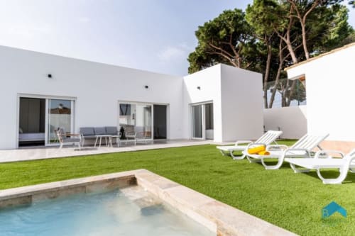 Villa moderna blanca Barrosa Home con piscina, tumbonas y jardín cuidado en España