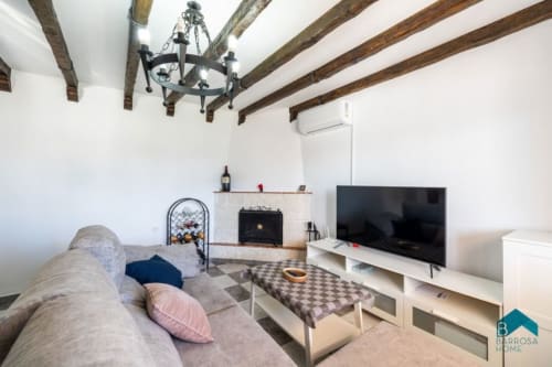 Moderno salón en Barrosa Home con vigas vistas, chimenea, televisor y cómodos asientos