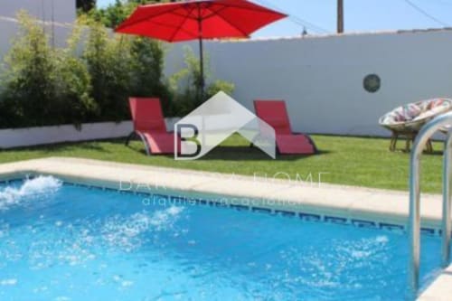 Zona de piscina Barrosa con tumbonas rojas, sombrilla y carpa blanca en España