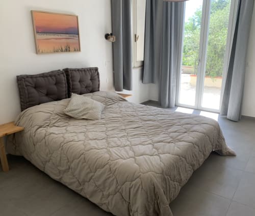 Camera luminosa a Ca' Salino BnB con letto trapuntato, testata scura e vista giardino dalle porte a vetri