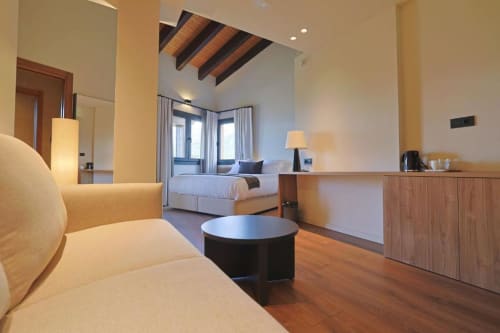 Spacious Deluxe Double Room at Hotel Fonsispa featuring bed, sofa, wooden accents, and mountain views