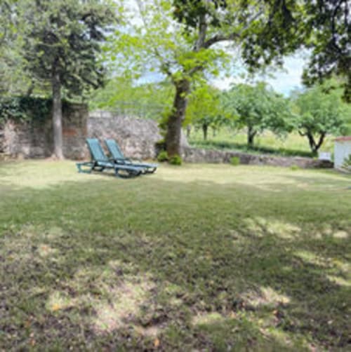 Espreguiçadeiras azuis sob árvores no jardim da Quinta do Carril em Reguengo, Portugal
