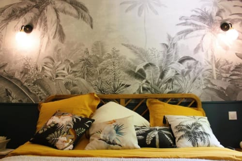 Chambre tropicale au Petit Bégou avec lit jaune moutarde, papier peint palmettes, coussins motifs