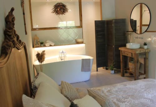 Suite chambre-salle de bain luxueuse au Petit Bégou B&B avec baignoire, vanité en bois et vue sur le jardin
