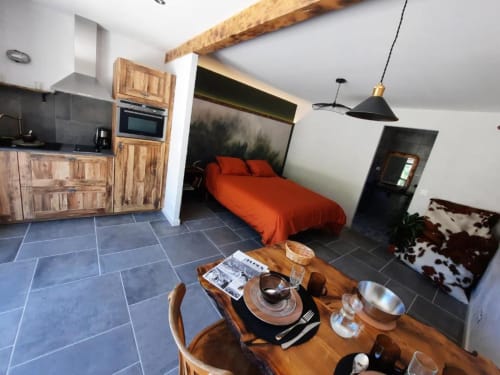 L'appartement La Bergerie de Roger du Petit Bégou dispose d'une cuisine, d'un coin repas et d'une chambre avec literie orange