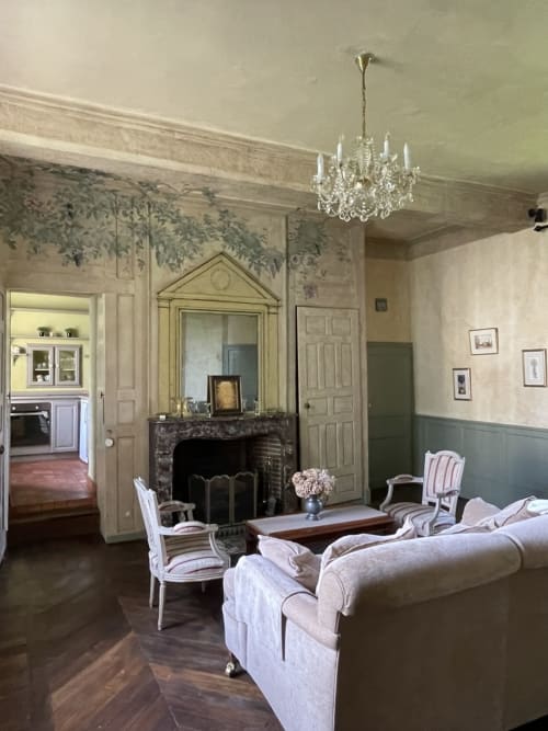 Élégant salon du Gîte Voltaire au Château de la Motte avec cheminée, lustre et mobilier d'époque