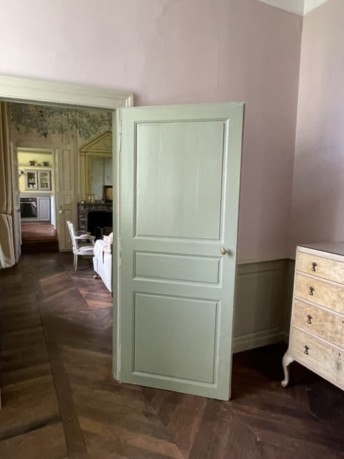 Porte vert pâle au Gîte Voltaire du Château de la Motte à Joué-du-Plain, avec vaisselier en bois et mobilier d'époque