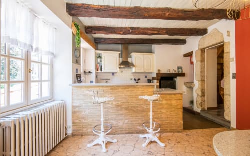Dourbie Cottage kitchen-bar area in Millau with exposed beams, brick counter, white bar stools, and mountain views