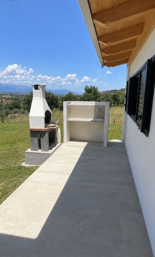 Terrazza Villa Maria con pergolato in legno, camino bianco, cucina esterna, vista sulla campagna, Cosenza