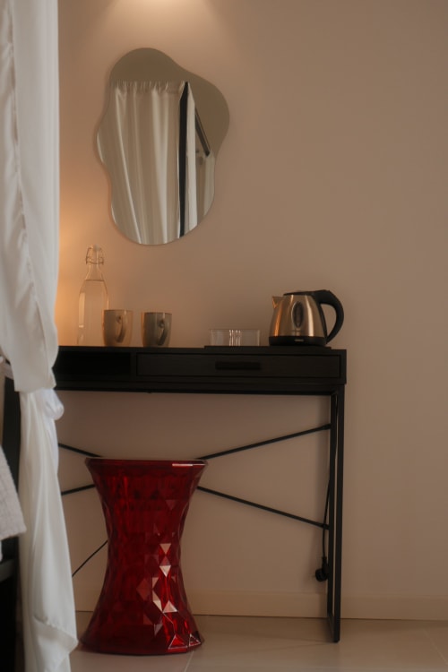 Modern desk with mirror and amenities at Nafura Hotel in Raffadali, Sicily