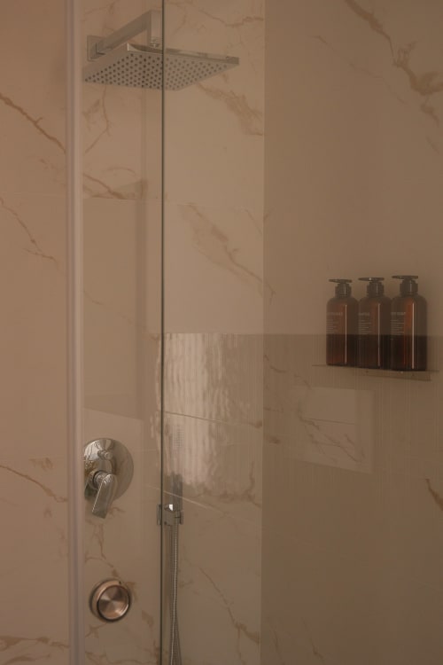 Modern shower in Zaira room at Nafura hotel, Raffadali, with rainfall showerhead and amenity bottles