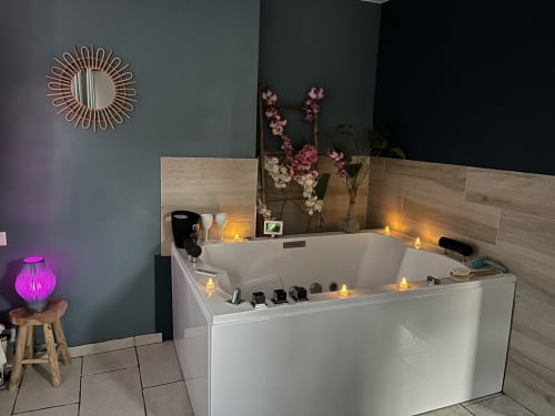 Salle de bain spa luxe de l'hôtel 4 étoiles Mb Room avec baignoire balnéo, bougies, fleurs et éclairage ambiant à Puget-sur-Argens