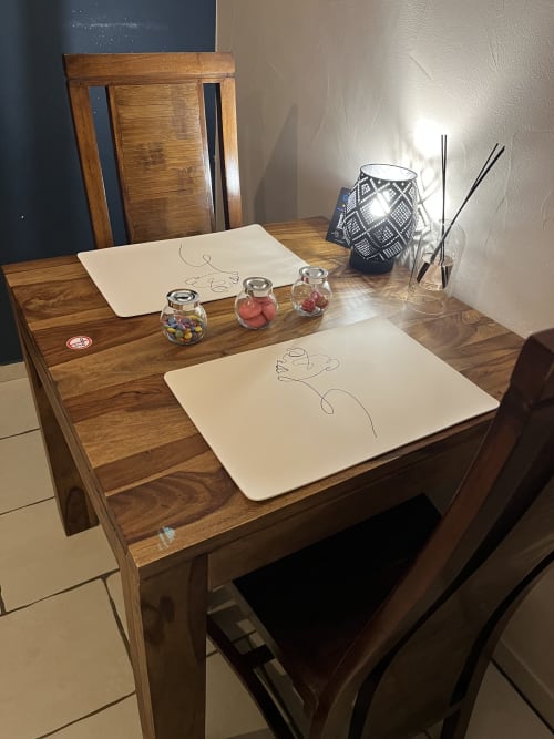 Bureau en bois dans la Suite Beauté de l'hôtel Puget-sur-Argens avec papiers à croquis, pots décoratifs et diffuseur