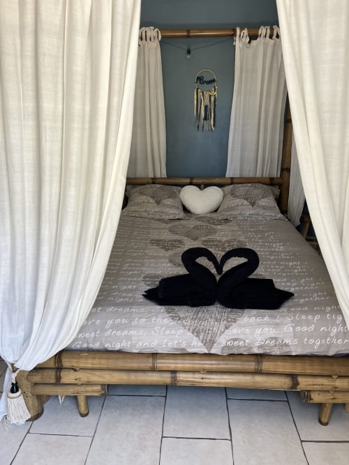 Lit à baldaquin romantique aux rideaux blancs, oreillers cygnes noirs et décoration cœur à la Suite Beauté de Mb Room, Puget-sur-Argens