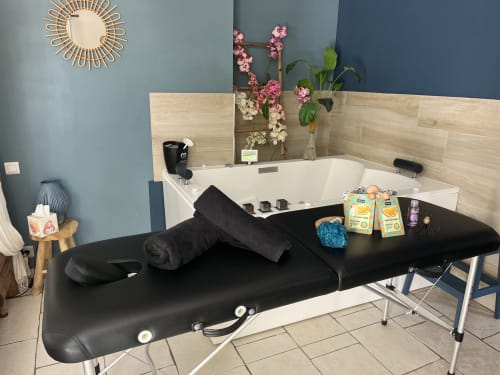 Table de massage de luxe dans la Suite Beauté du Mb Room avec bain Jacuzzi et fleurs roses à l'hôtel 4 étoiles du Var