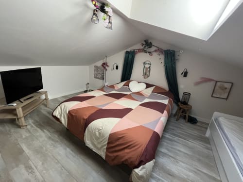 Chambre mansardée douillette au Mb Room 4 étoiles à Puget-sur-Argens avec literie patchwork colorée, lucarne, TV et vue sur jardin