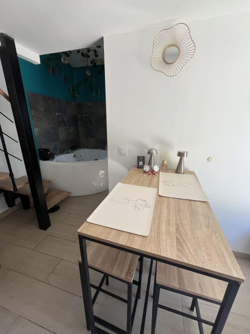 Suite de bain moderne avec bureau en bois, baignoire balnéo et miroir décoratif à l'hôtel Mb Room Var