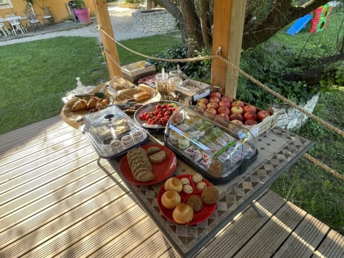 Buffet petit-déjeuner en plein air aux Jardins Du Soleil à Avignon avec pâtisseries fraîches, fruits et viennoiseries par beau temps
