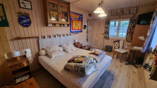 Chambre cosy aux Chambres d'hôtes le Clos du Tay à La Gacilly avec décor bois, enseignes vintage et literie fleurie