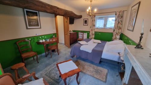 Chambre spacieuse aux Chambres d'hôtes le Clos du Tay à La Gacilly avec lits jumeaux, murs verts, poutres rustiques et style vintage