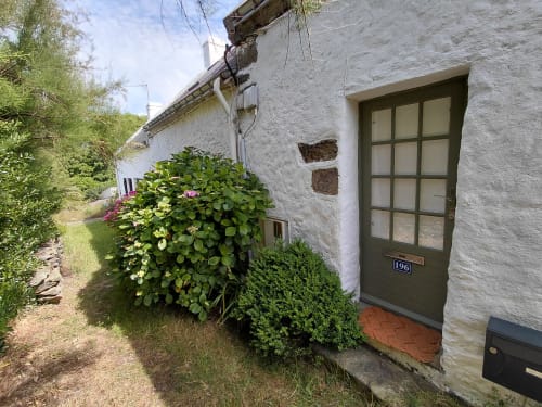 Charmante entrée de maison blanche avec porte verte numérotée 196, arbustes fleuris et vue sur le jardin à Sauzon, Belle Île en Mer
