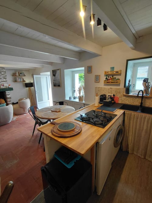 Cuisine moderne et salle à manger du gîte Kergue'ch, Belle Île-en-Mer, avec îlot en bois, cuisinière à gaz et espace de vie