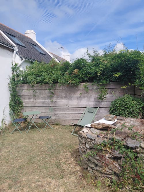 Patio de maison de campagne avec chaises de camping et mur en pierre, Belle-Île-en-Mer
