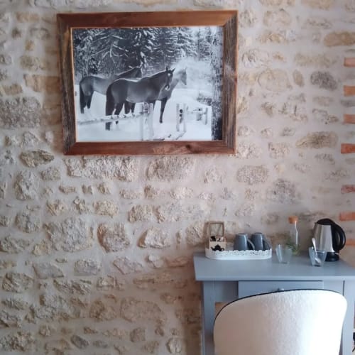 Photo en noir et blanc encadrée de chevaux en forêt enneigée au-dessus du bureau dans la chambre Le Chant de la Cloche à La Maison De Fleurat