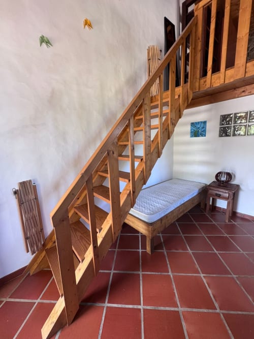 Quarto tipo loft em madeira no T Monte B&B em Porto Côvo, Portugal, com piso de azulejos vermelhos e decorações com vista para o jardim