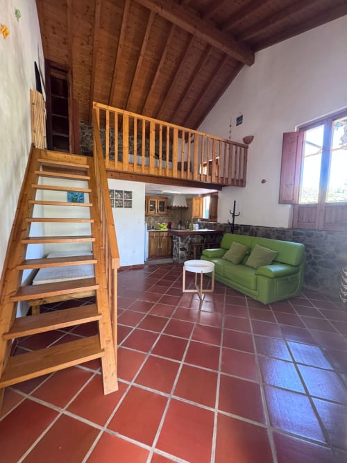 Espaçoso loft-estilo em T Monte Porto Côvo com escadas de madeira, mezanino, sofá verde, cozinha e azulejos de terracota
