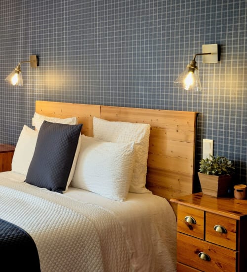 Chambre moderne à La Maison De Fleurat avec tête de lit en bois, literie blanche, appliques murales en laiton et murs carrelés gris