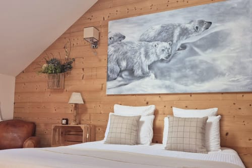 Chambre douillette en bois à La Maison De Fleurat avec œuvre polaire, literie blanche, coussins beige et décor rustique.