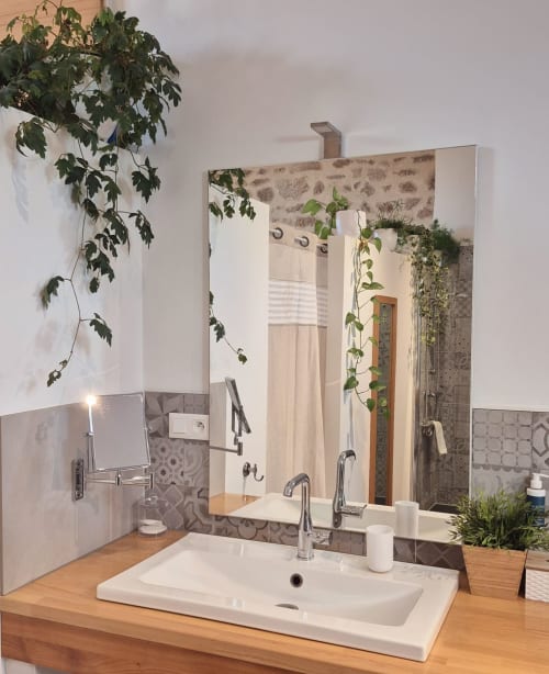 Salle de bain moderne avec vasque, meuble en bois, grand miroir et plantes vertes à La Maison De Fleurat, Domeyrot