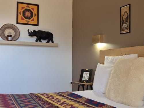 Chambre douillette à La Maison De Fleurat avec literie blanche, tête de lit en bois, jeté aux motifs ethniques et décoration