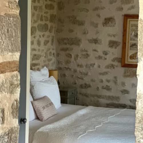 Chambre douillette à La Maison De Fleurat à Domeyrot avec papier peint fleuri, literie blanche et vue sur le jardin