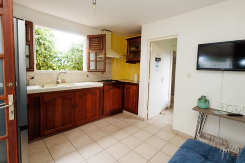 Cuisine et séjour du cottage Kaz La Brise à Otantik Caribbean, Le Gosier avec meubles en bois et vue sur le jardin