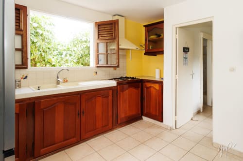 Cuisine du cottage Kaz La Brise à Otantik Caribbean, Le Gosier, avec armoires en bois rouge et murs jaunes