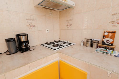 Coin cuisine de la villa Lueur du Sud avec cuisinière à gaz, cafetière et rangements dans Otantik Caribbean