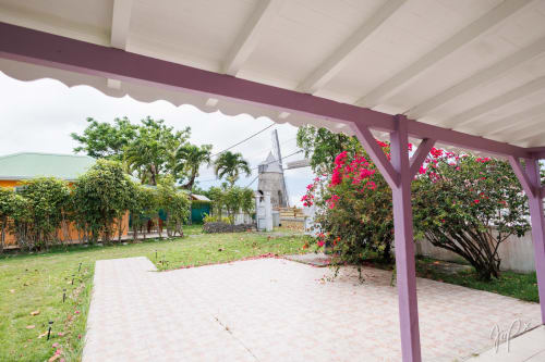 Pergola violette surplombant les jardins soignés et le moulin de la villa Otantik aux Caraïbes en Guadeloupe